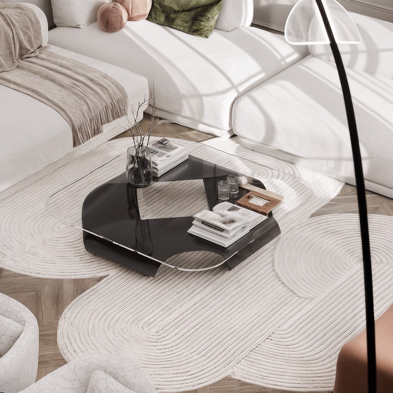 Black glass coffee table above a textured cream rug in a softly lit living room.