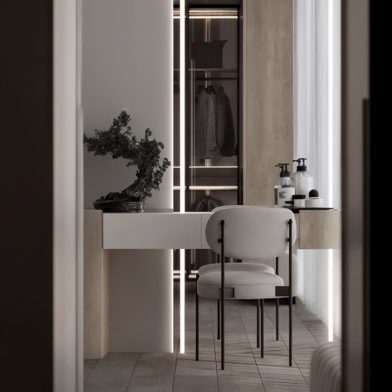 View through a doorway to a lit vanity desk and open wardrobe in a neutral bedroom.